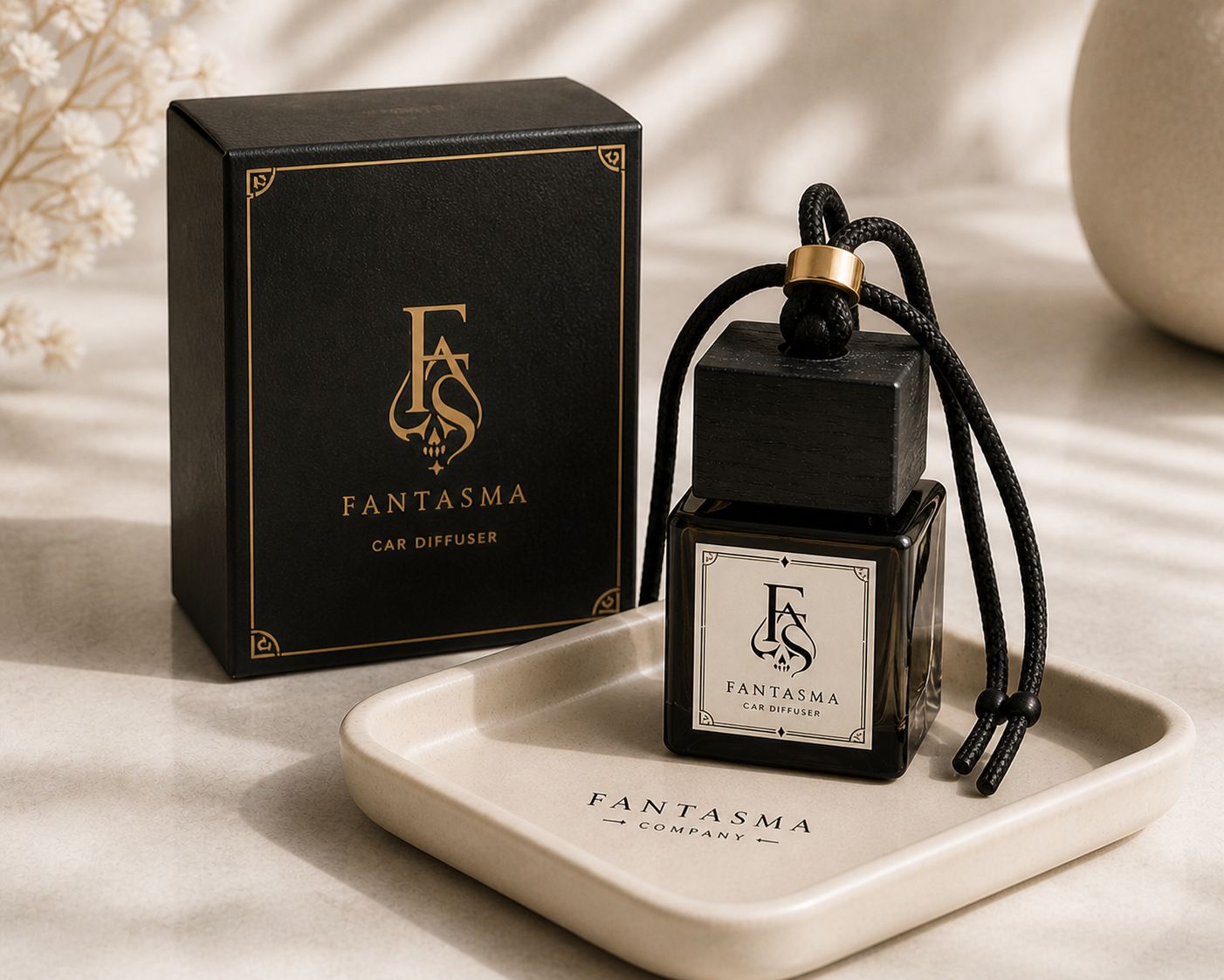Fantasma black square car diffuser with braided cord and boxed packaging.